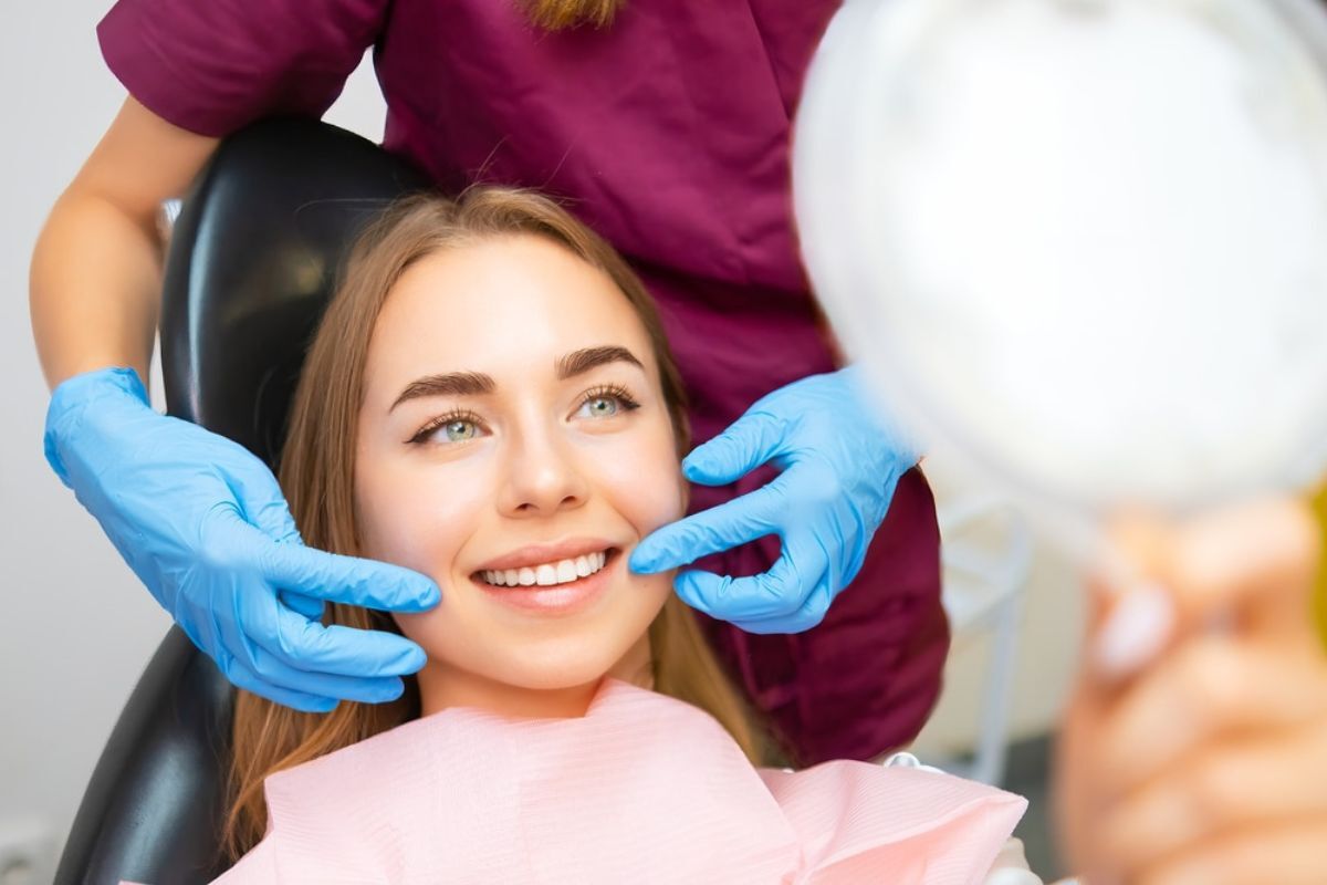 Smiling patient receiving cosmetic dental examination from dentist in Duxbury.