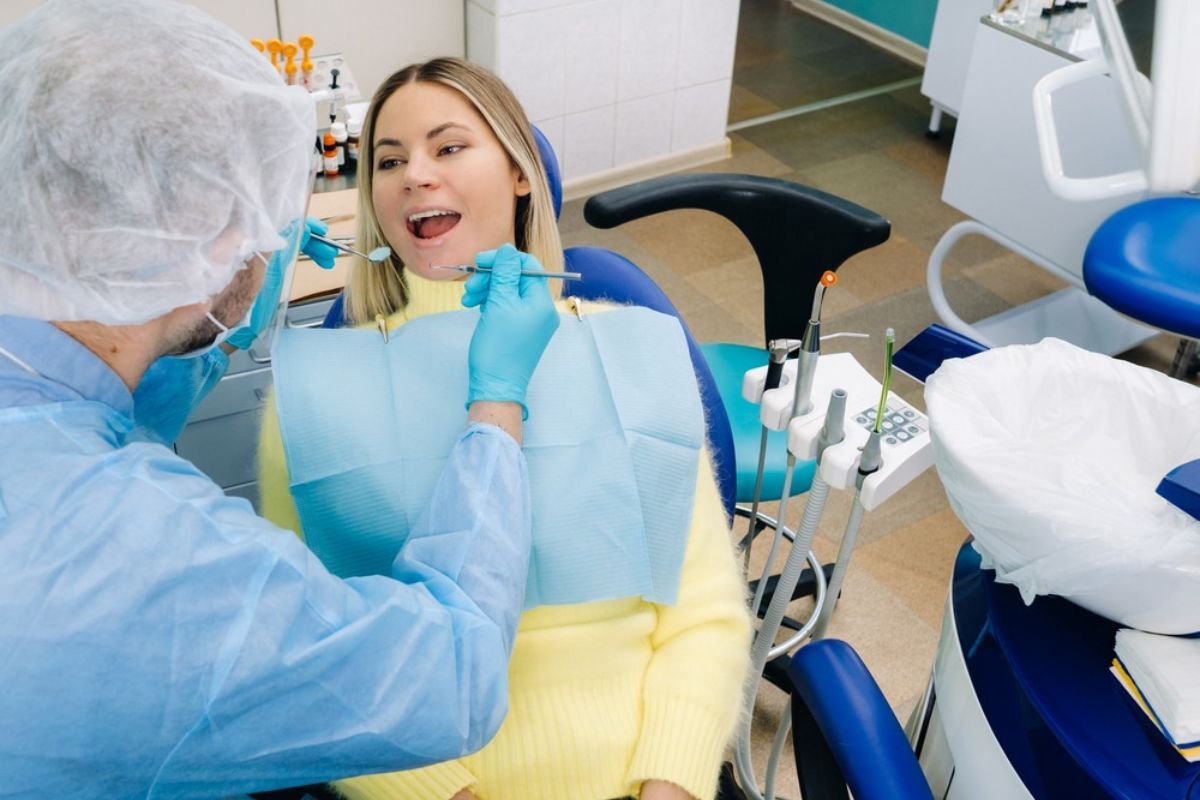 Dentist examining patient's teeth during restorative dental treatment in Duxbury.