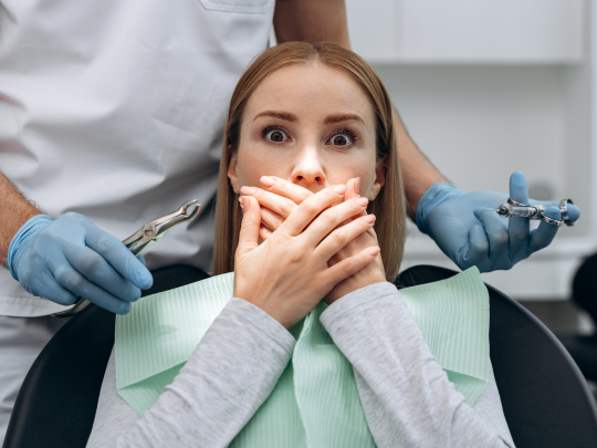 My Tide Dental Ortho Dental Emergency Nervous patient covering her mouth during dental appointment with anxious expression.