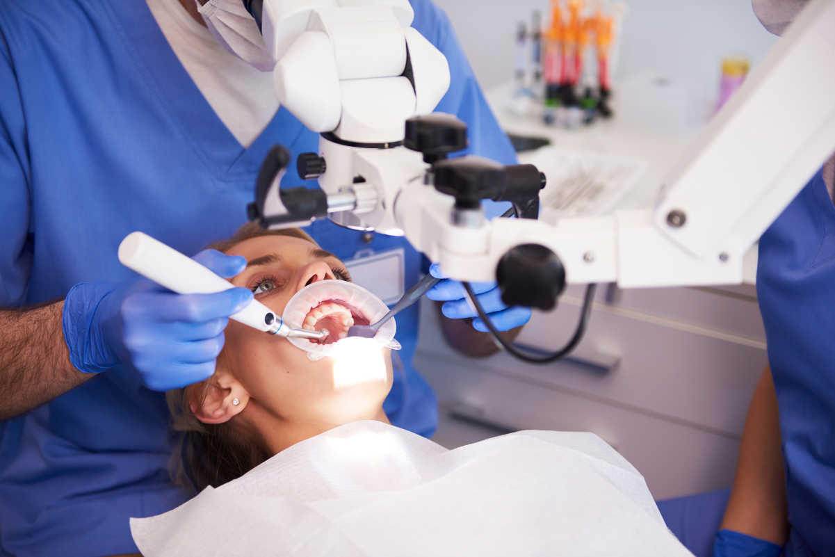 How Dentists Prioritize Treatment When Multiple Dental Issues Exist Dentist examining patient's teeth during treatment with dental microscope in modern practice.