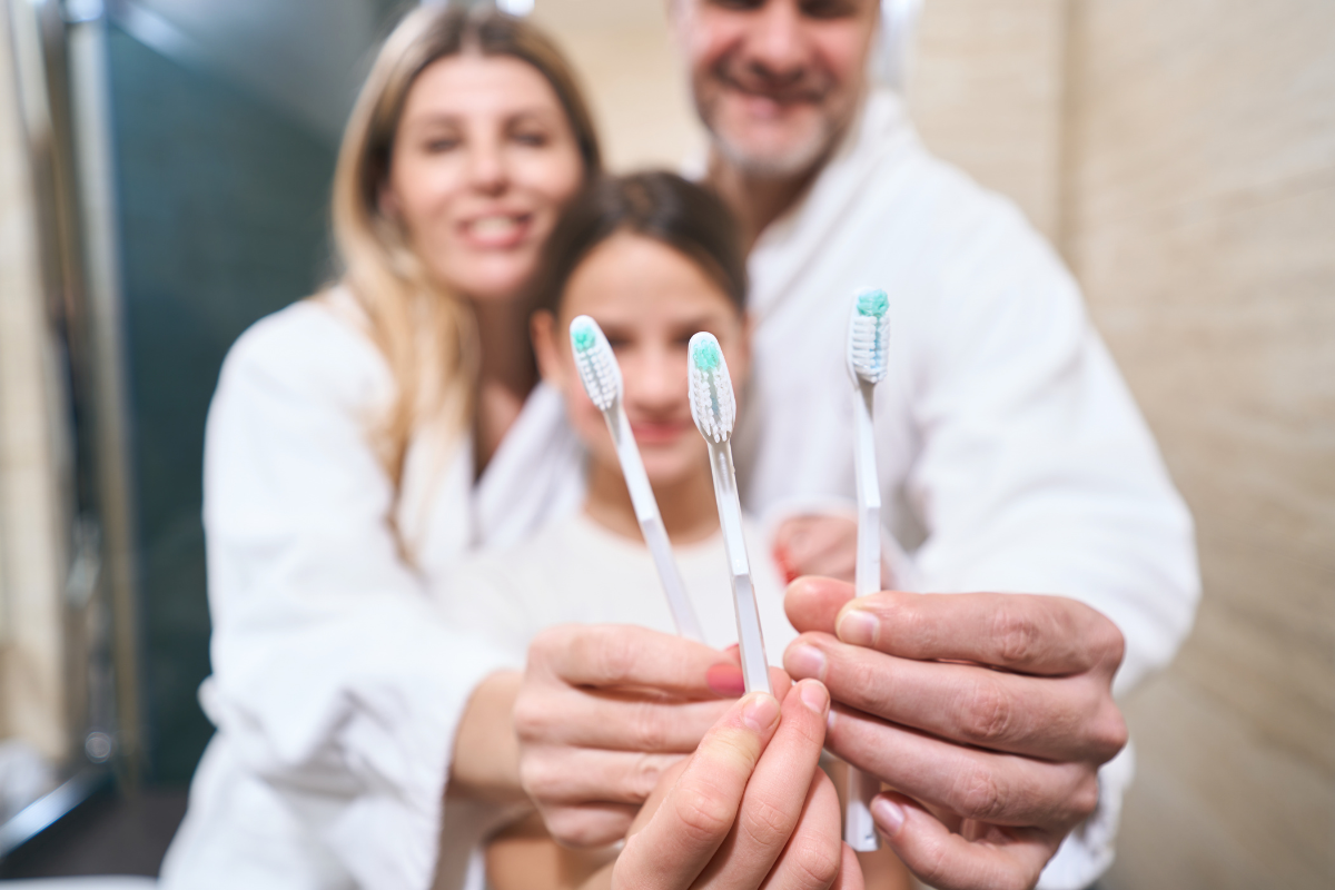What Is Family Dentistry and How Is It Different from General Dentistry Family dentist showing toothbrushes with child and mother at Duxbury dental practice.