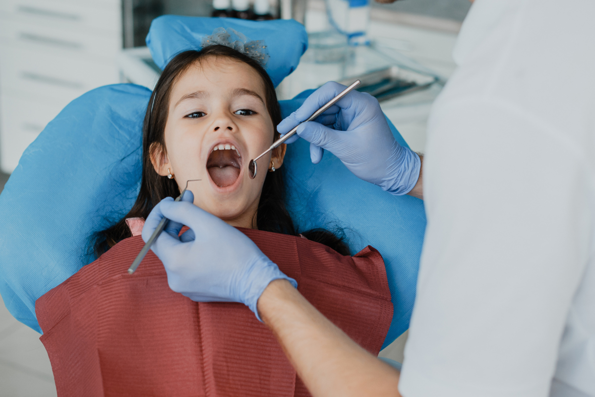 Young patient receiving dental examination in chair at Duxbury dental office.