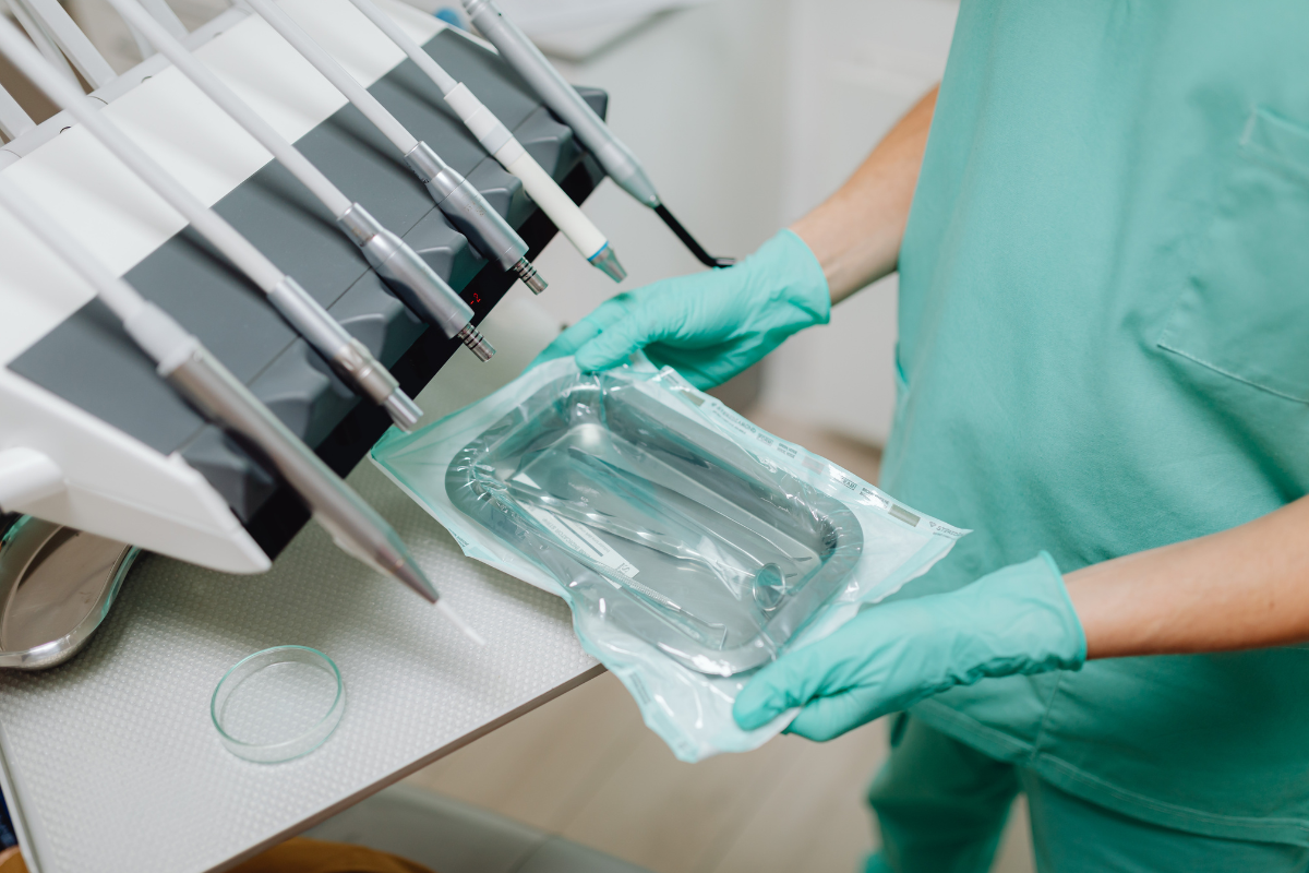 Sterilization Methods in Dentistry_ Keeping Patients Safe Dental professional in sterile gloves opening sterilized instrument package during sterilization procedure.