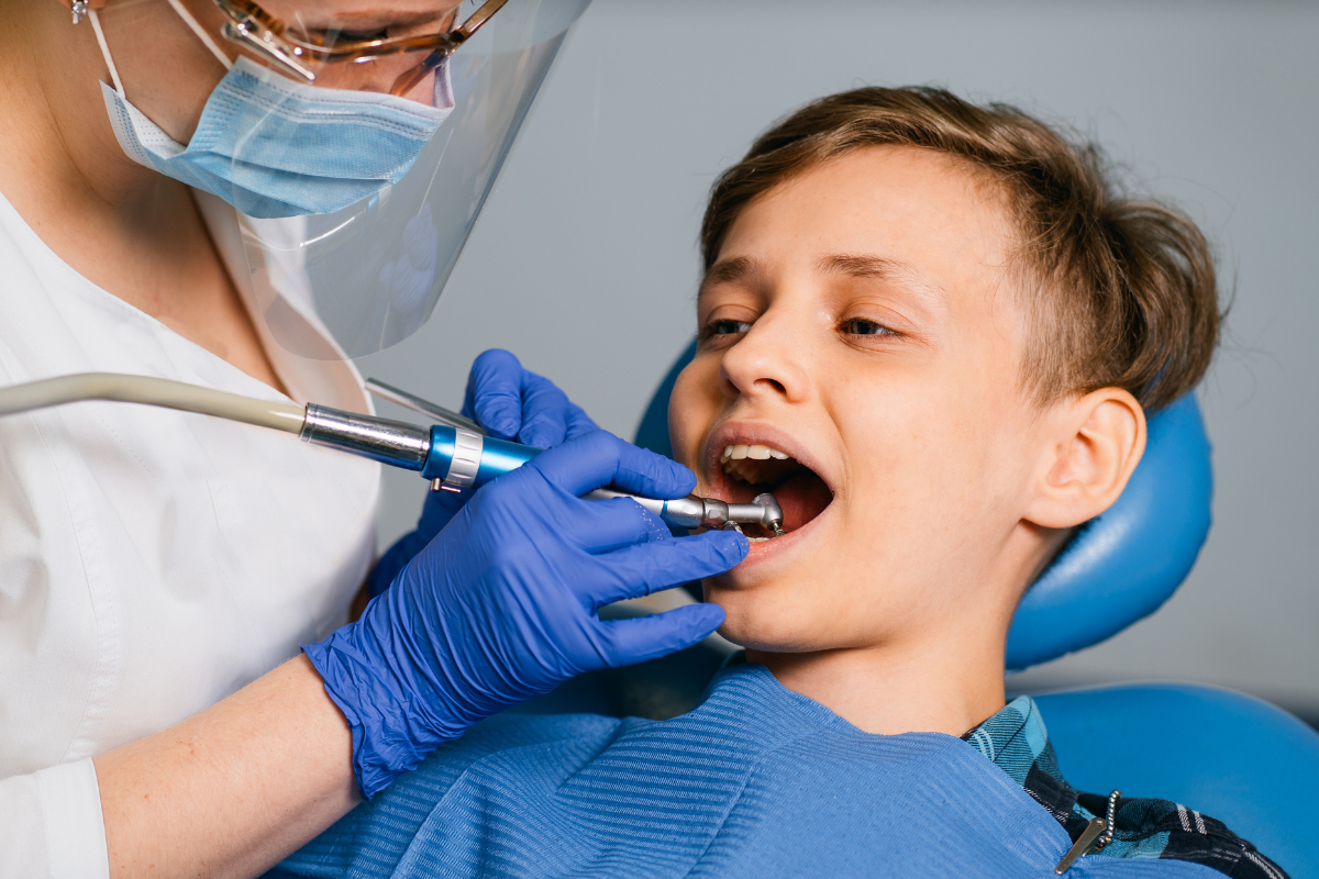 Young patient receiving dental treatment with modern equipment at Duxbury dental practice.